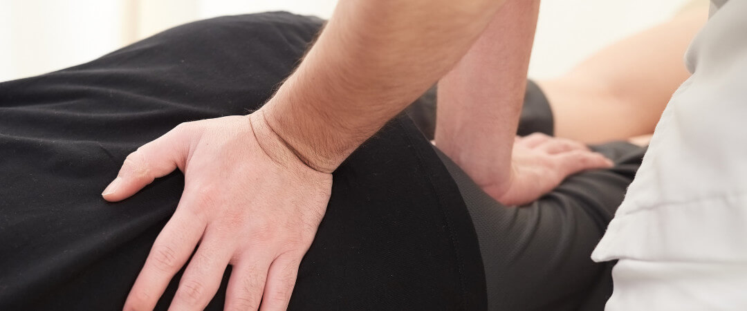 Therapist massaging mans shoulder in gym hospital